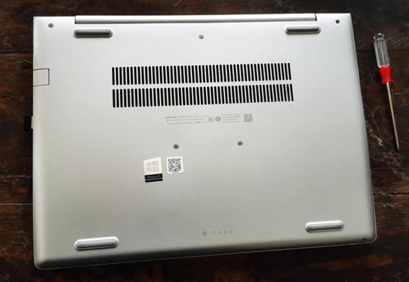 the bottom of the HP laptop and a screwdriver